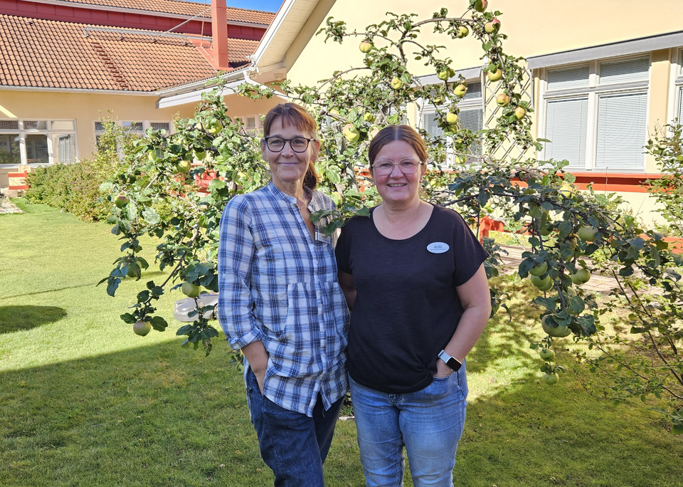Två kvinnor som står i en trädgård